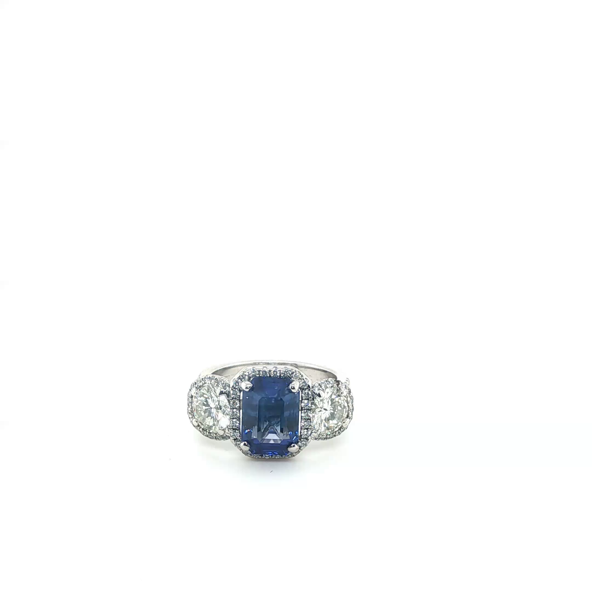 Emerald-Cut Blue Sapphire and Diamond Three-Stone Halo Ring in White Gold